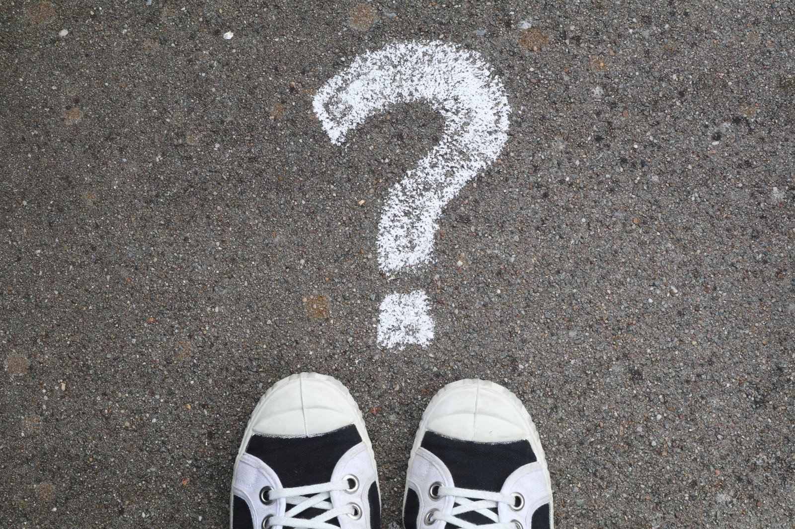 A chalk question mark on pavement, representing the questions asked about Darkness in a Lighthouse